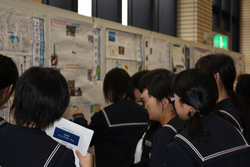 生徒手作りの壁新聞を見ている女子生徒
